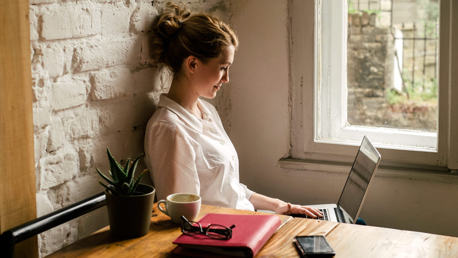 businesswoman-working-on-a-laptop_by_window_WM18203_224503_St_1560x880