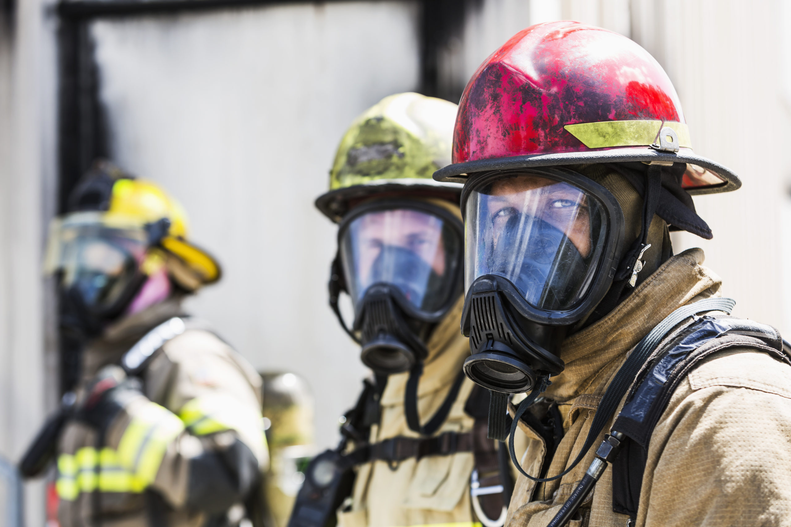 Three firefighters wearing oxygen masks
