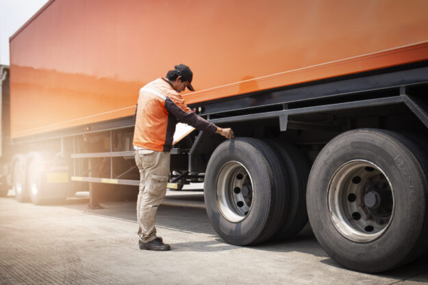Auto Mechanic Checking a Truck Wheels Tires. Truck Inspection Maintenance Safety Driving.
