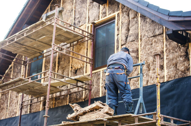 Man on Scaffolding A construction worker standing on elevated scaffold while building.