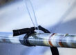 Close up photo of burst metal water pipe, forcefully shooting a stream of water up into the air.
