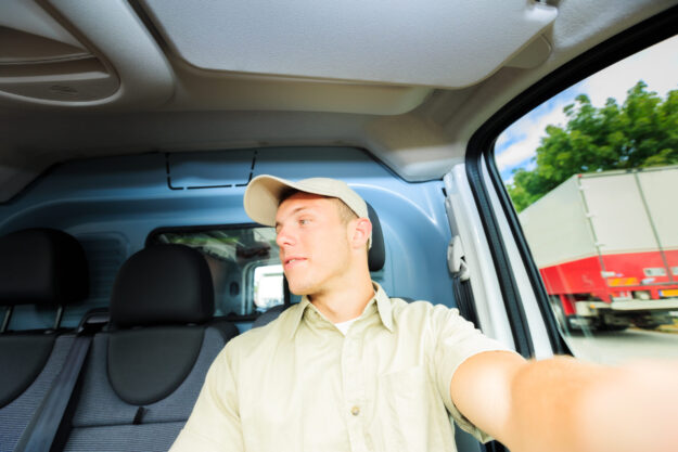 A distracted delivery driver looks out the passenger-side window.