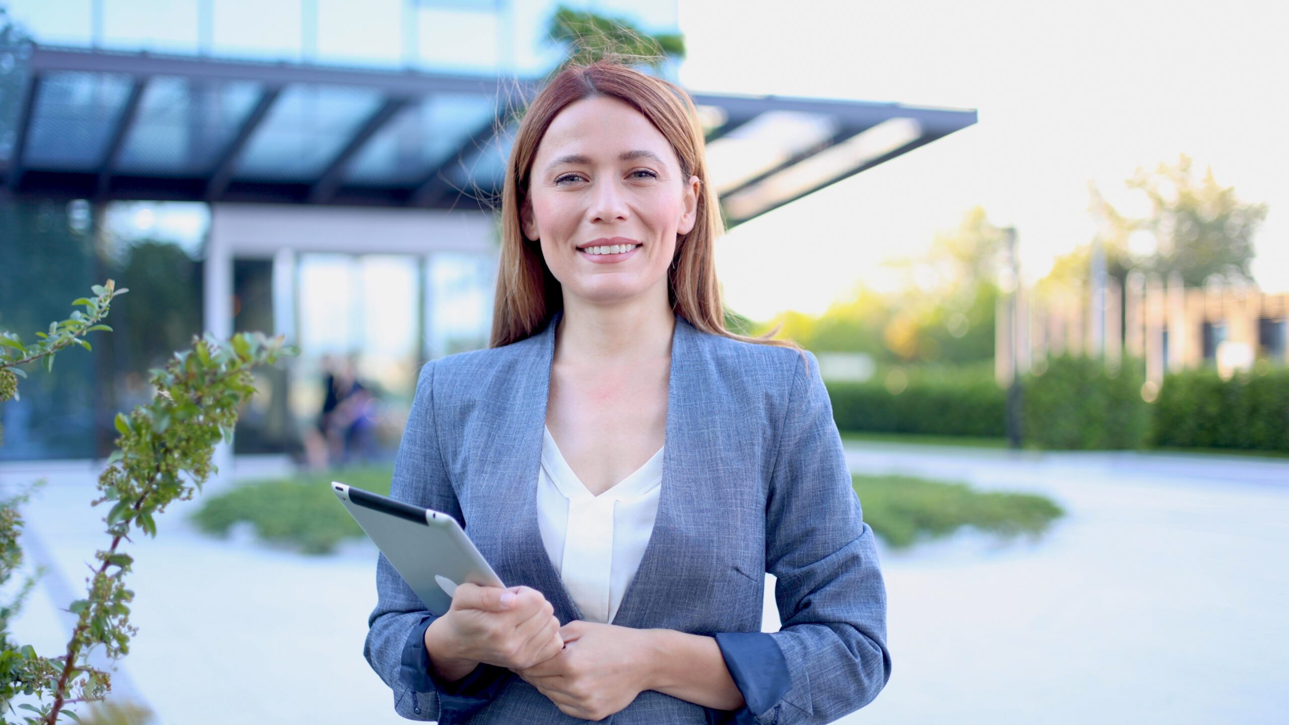 Portrait of a smiling association manager standing outdoors in front of her condo office