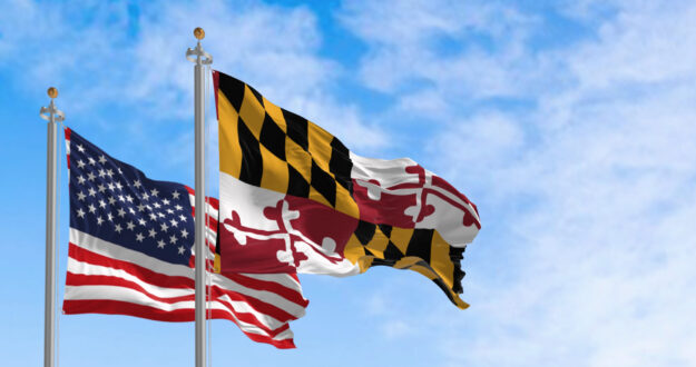 Flags of Maryland and of the United states waving in the wind on a clear day